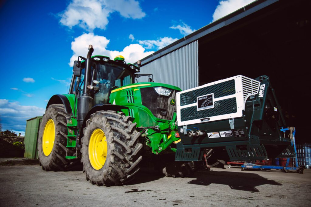 The Varimount 350 PTO Compressor being driven by a tractor next to a storage unit
